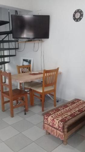 um quarto com uma mesa e cadeiras e uma televisão em La casa del marino em Concepción del Uruguay