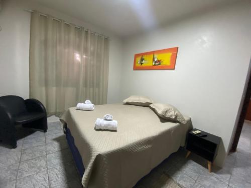 a bedroom with a bed with two towels on it at Espaço confortável no centro da cidade in Foz do Iguaçu