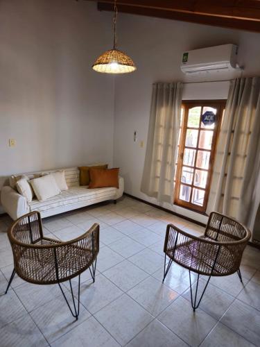 uma sala de estar com duas cadeiras e um sofá em La Primi em Guaymallén