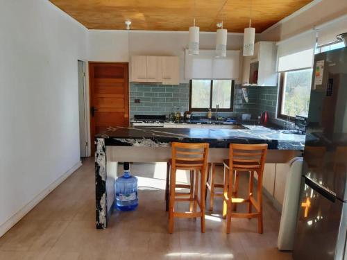 a kitchen with a island with four chairs in it at DIAGUITAS, VICUÑA, VALLE DEL ELQUI in Diaguita