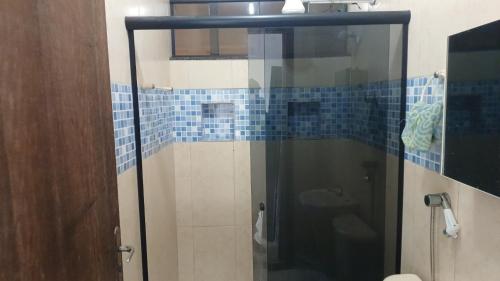 baño con ducha de cristal con azulejos azules en Ro Rooms, en Rio Grande da Serra