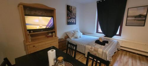 a room with a bed and a table with a television at Central Belgium in Brussels