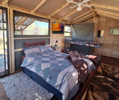 a bedroom with a large bed in a cabin at Thorn Tree Bush Camp in Klipdrift