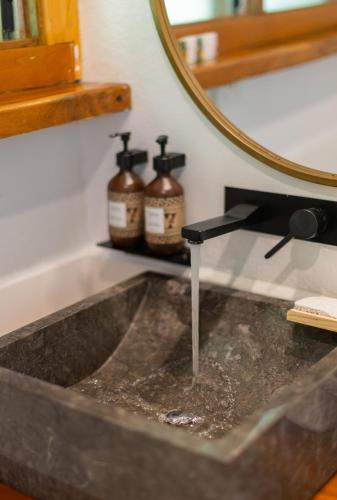 a bathroom sink with a mirror and a water fountain at Koro Sun Resort & Rainforest Spa in Savusavu