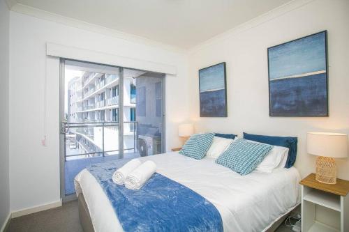 a bedroom with a large bed with blue and white pillows at Seaside Bliss in Perth