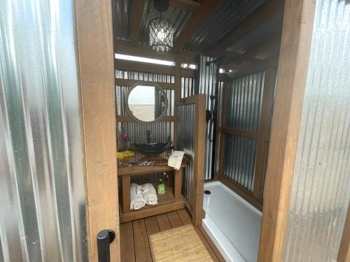 a small bathroom with a sink and a mirror at Tiki Cabana in Hawaiian Ocean View