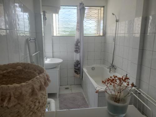 a bathroom with a tub and a sink and a toilet and a bath tub at Hébergement en rez-de jardin clos proche de l'aéroport et des commodités in Le Lamentin