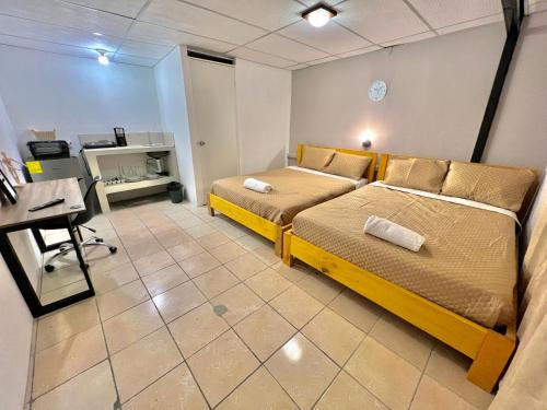 een slaapkamer met twee bedden en een bureau erin bij Citadin Yurrita in Guatemala