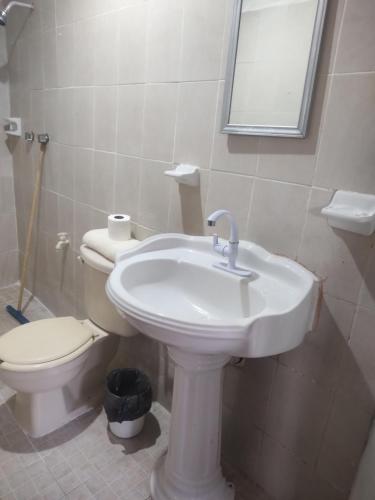 ein Badezimmer mit einem weißen Waschbecken und einem WC in der Unterkunft Departamento en Campeche estación del tren maya in Campeche
