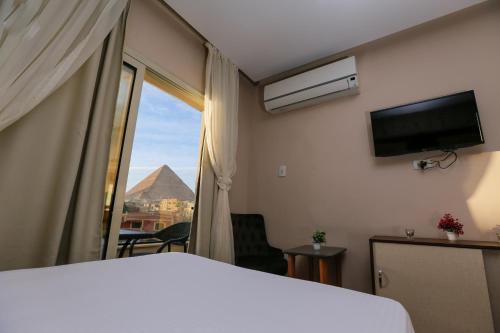 una camera con letto e finestra con vista di Sky Pyramids View Inn a Il Cairo