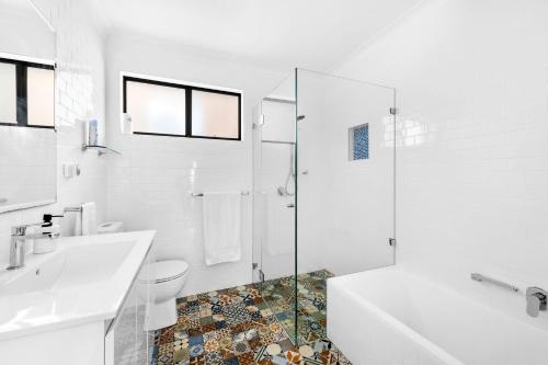 a bathroom with a toilet and a sink and a shower at Villa Del Mar - Belle Escapes Jervis Bay in Vincentia