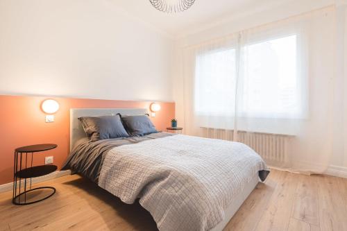 une chambre blanche avec un grand lit et une fenêtre dans l'établissement Apartment - Le Bloom In the heart of Annecy, à Annecy