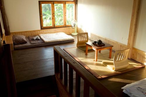 Habitación con 2 sillas, mesa y cama en บ้านฮิดะ หางดง, en Ban Phae Khwang