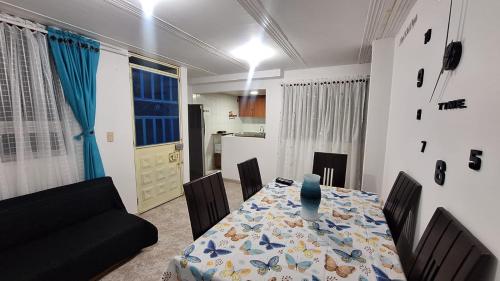 a dining room with a table and chairs and a kitchen at Habita Living Bogotá in Bogotá