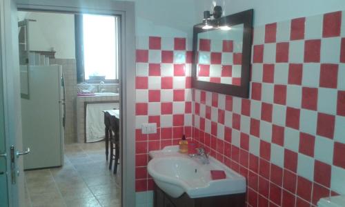 a bathroom with a sink and red and white tiles at Dammuso Donna Giovanna in Scicli