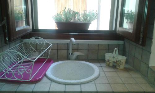 a bathroom with a sink and a window at Dammuso Donna Giovanna in Scicli