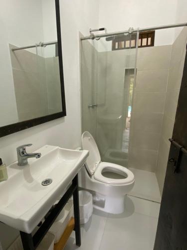 a bathroom with a toilet and a sink and a shower at Finca ganadera de lujo en el Quindío in Pueblo Tapao