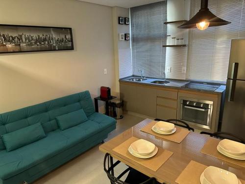 a living room with a blue couch and a table at LOFTS CARIJOS CENTRO BH in Belo Horizonte