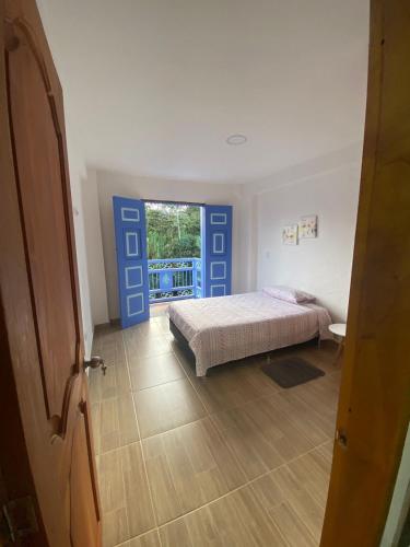 a bedroom with a bed and a door with a window at Apartahotel Villa Carolina 3 in Jericó
