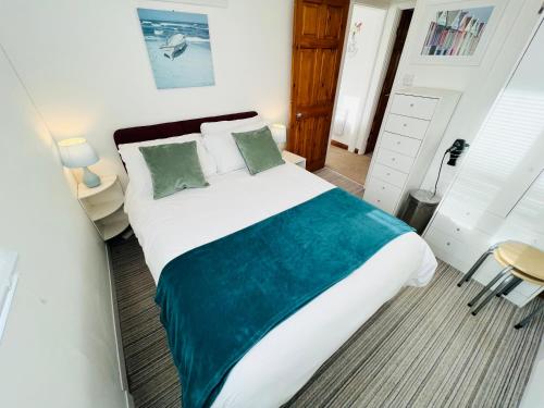 um quarto com uma cama grande com lençóis verdes e brancos em 2 Bedroom Chalet SB11, Sandown Bay, Dog Friendly em Sandown