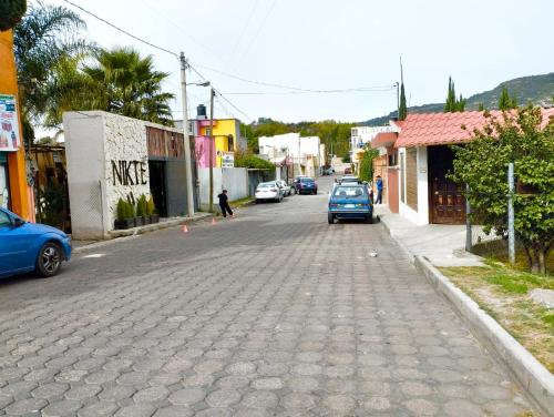 una strada di ciottoli in una città con auto parcheggiate di Hermosos departamentos a 8 minutos del centro a Totolac