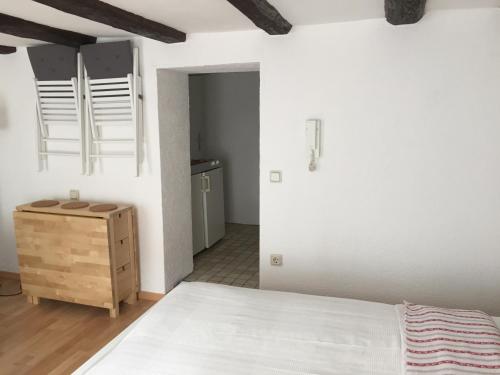 sypialnia z białym łóżkiem i drewnianą komodą w obiekcie Baumeisterhaus Apartment w mieście Bad Hersfeld