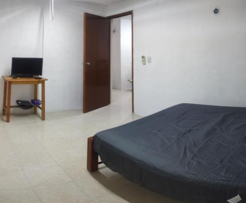 1 dormitorio con 1 cama y escritorio con ordenador en Departamento en Campeche estación del tren maya en Campeche
