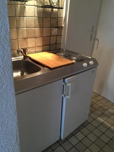 cocina con fregadero y tabla de cortar de madera en Baumeisterhaus Apartment, en Bad Hersfeld