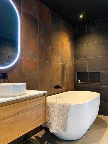 een badkamer met een bad en een wastafel bij 'Shore Thing' - Akaroa in St Helens