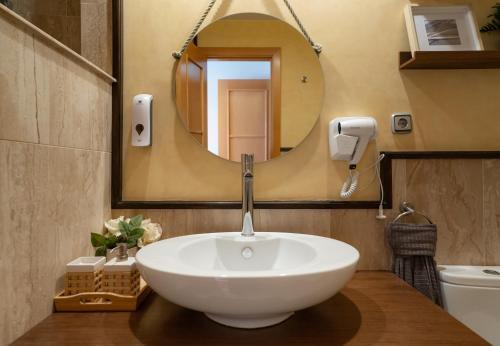 een badkamer met een witte wastafel en een spiegel bij MAR Y MONTAÑA in Torremolinos