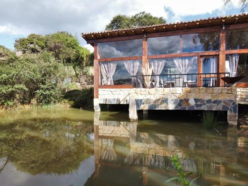 a house on a bridge over a body of water at Cabaña Isla Dorada in Guatavita