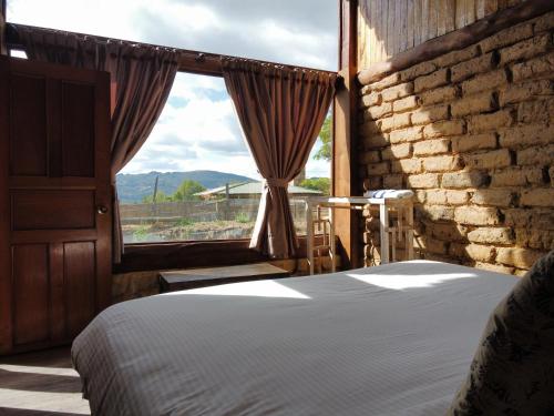 a bedroom with a bed and a large window at Cabaña Isla Dorada in Guatavita