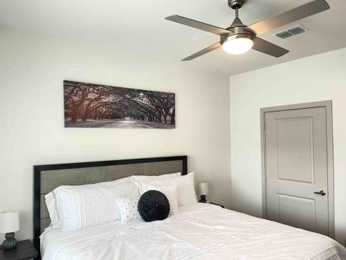 a bedroom with a white bed with a ceiling fan at Modern 1br - 15 from Airport in Stockbridge