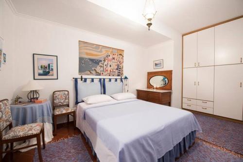 Un dormitorio con una gran cama blanca y una mesa en Loukas House, en Palaión Tsiflíkion