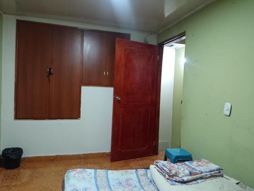 um quarto com um armário, uma cama e uma porta em Alojamiento Don Luis em Popayan