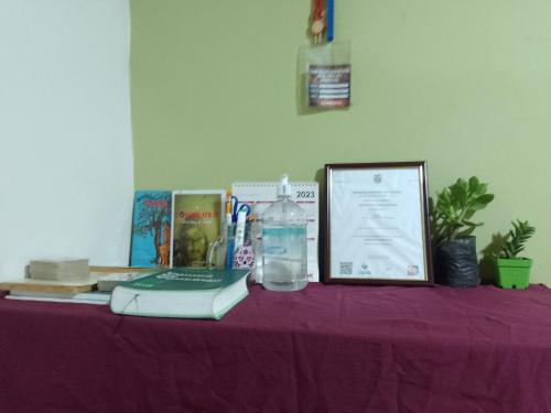 una mesa púrpura con un libro y una botella de agua en Alojamiento Don Luis en Popayán