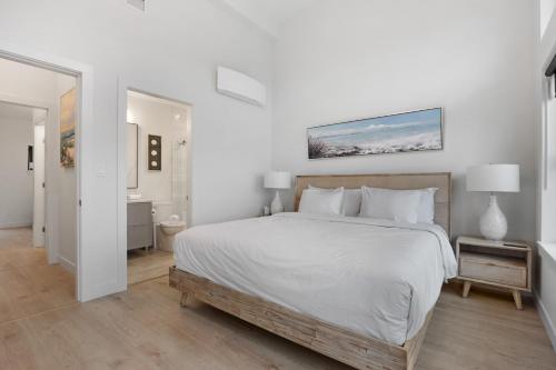 biała sypialnia z dużym łóżkiem i łazienką w obiekcie Ocean View Townhouse #23 at THE BEACH HOUSE w mieście Campbell River