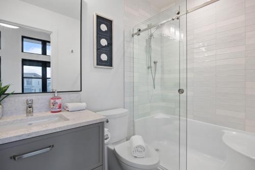 a white bathroom with a shower and a toilet at Ocean View Townhouse #23 at THE BEACH HOUSE in Campbell River