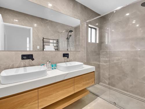 a bathroom with two sinks and a glass shower at Casa Siboney in Horseshoe Bay
