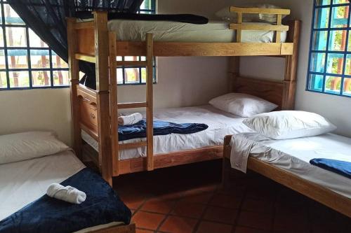 a room with three bunk beds in a house at La Escondida, con acceso al lago in Guatapé