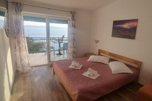 a bedroom with a bed and a large window at Apartments with parking space Zivogosce - Porat, Makarska - 16289 in Živogošće