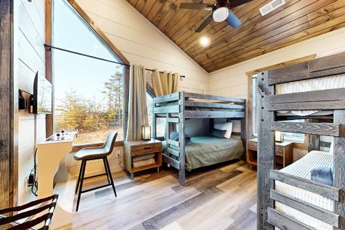 a bedroom with two bunk beds and a desk at Little Sister's Cabin in Pigeon Forge
