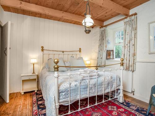 um quarto com uma cama e um tecto de madeira em Hallowarren Barn em Saint Anthony