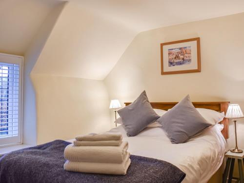 a bedroom with a bed with towels on it at Flanders Cottage in Lymington