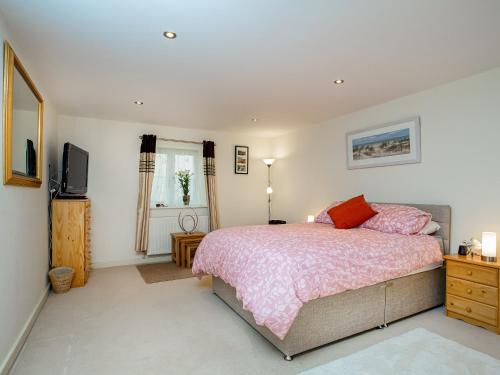 a bedroom with a bed and a television in it at Oversands in Torquay