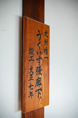 a wooden sign with chinese writing on a wall at Kagetsu Taisyokan in Takeo