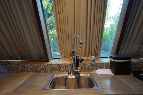 um lavatório de cozinha com uma torneira em frente a uma janela em NOVÍSSIMOS Chalés Alto Padrão com Jacuzzi no Centro de Bonito em Bonito