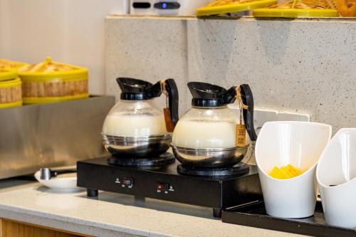 two containers of milk on a counter in a kitchen at Wuyu Hotel - Chongqing Jiangbei Airport & Light Rail in Chongqing