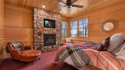 Blockhausschlafzimmer mit Kamin und Bett in der Unterkunft Shady Pines On Kimble Lake in Pequot Lakes