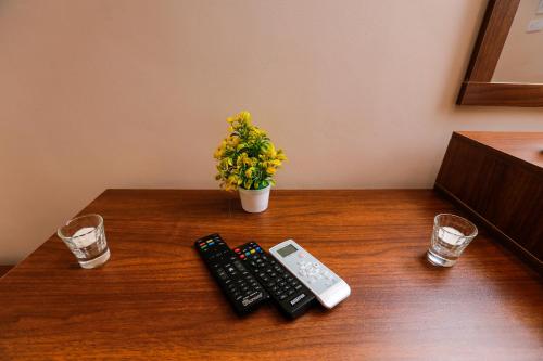 a table with two remote controls and a cell phone at Sky Pyramids View Inn in Cairo